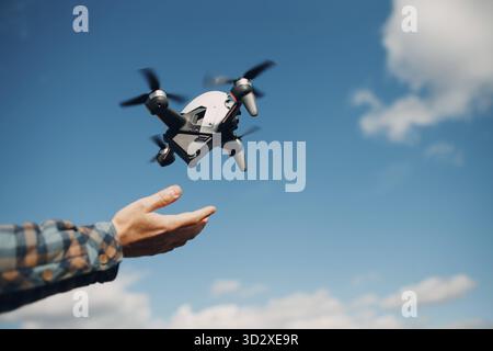 Man pilot Launches quadcopter drone from hand to sky flight Stock Photo