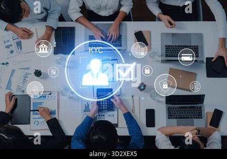 A group of professionals collaborates on KYC processes, utilizing high-tech devices and discussing information in a modern office setting filled with Stock Photo