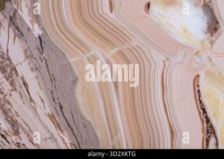 Close-up view of natural marble texture, featuring warm beige and pinkish hues with unique layered patterns Stock Photo
