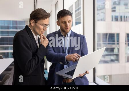 Serious young male business project partners using laptop computer Stock Photo