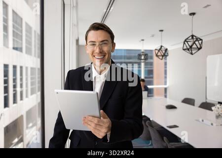 Happy handsome young business professional man using tablet Stock Photo