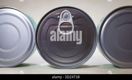 three food cans on their side showing ring-pulls on white background – canned goods packaging still life Stock Photo
