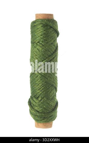 Green jute twine or natural fiber rope wrapped around a wooden spool on a white background, isolated vertical image Stock Photo