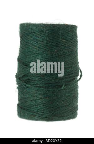 Dark green natural fiber twine or yarn tightly wound on a brown spool, isolated against a plain white background Stock Photo