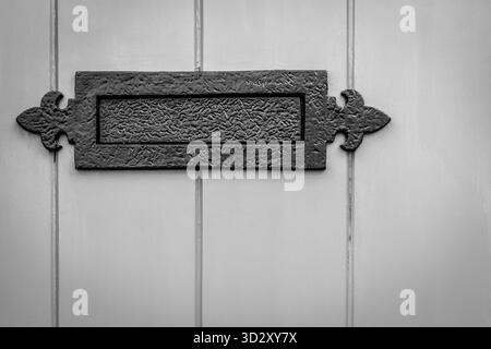 Vintage Metal Letter Plate With Ornate Hinges Mounted On Light Wood Door Stock Photo