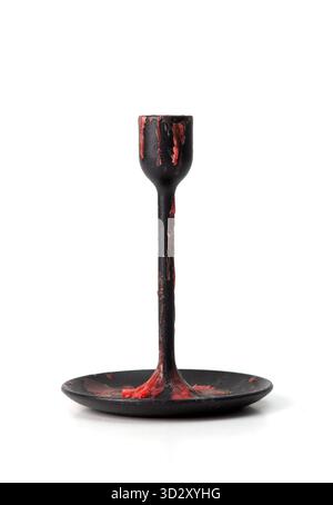 Black metal candle holder covered with red wax drips, isolated on white background, gothic style object Stock Photo