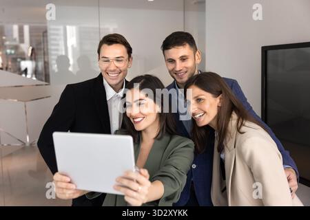 Four cheerful excited business colleagues laughing and shouting at camera Stock Photo