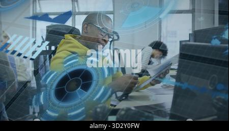 Taking notes African American man in yellow hoodie using pen on notebook in collaborative office Stock Photo