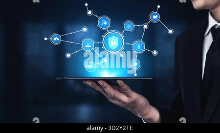 A businessman in a suit holds a tablet displaying a futuristic digital security interface. The image conveys concepts of cybersecurity, technology, an Stock Photo