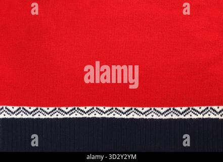 Horizontal or vertical Christmas background with knitted fabric. Wool sweater texture of red, dark blue color with white border. Natural knitted wool Stock Photo