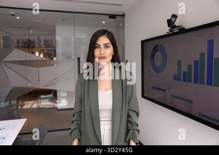 Confident beautiful young Latin business woman posing in office Stock Photo