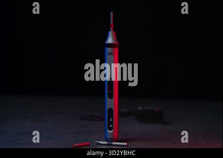 Electric mini screwdriver and several different interchangeable bits Stock Photo
