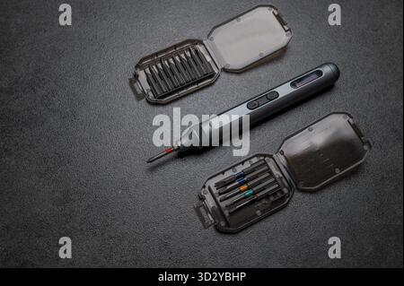 Electric mini screwdriver and several different interchangeable bits Stock Photo