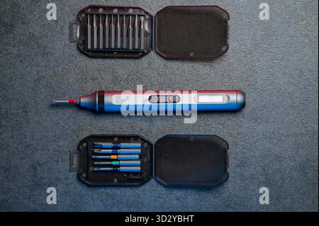 Electric mini screwdriver and several different interchangeable bits Stock Photo