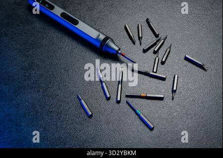 Electric mini screwdriver and several different interchangeable bits Stock Photo