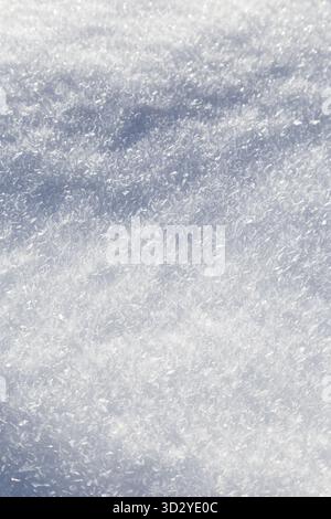 Close-up of fresh and bright snowy land in the winter, viewed from above. Abstract full frame textured background with copy space. Top view. Stock Photo