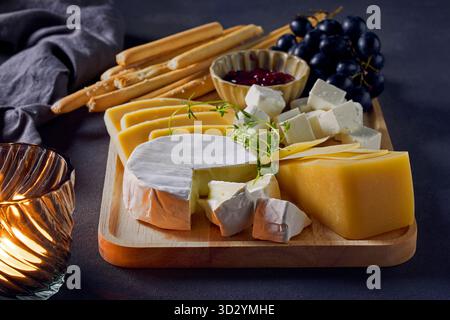cheese plate and bread sticks on dark grey table background Stock Photo