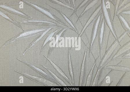 Embossed bamboo leaves on metallic fabric, neutral beige tapestry background Stock Photo