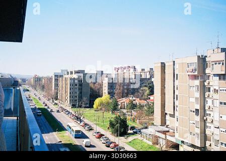 High-floor view of Narodnog Fronta Street in Novi Sad on a sunny day, featuring strong brutalist architecture and clear urban lines. Stock Photo