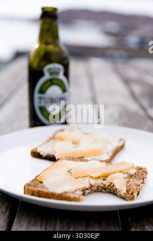 Bread with smoked halibut, Tuborg beer in a bottle.  Narsaq, South Greenland. Stock Photo