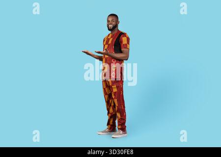 Portrait of young black muslim man praying on blue studio background Stock Photo