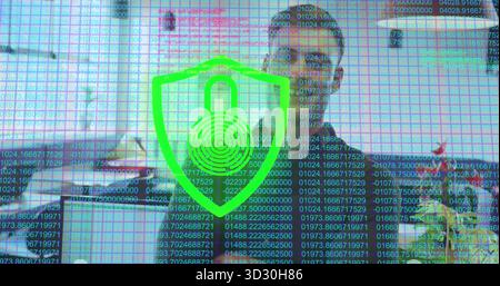 Displaying green shield emblem with code streams over office desk, with computer monitor, keyboard Stock Photo
