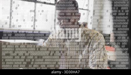 Typing software developer entering code on computer at desk in office, with binary code, copy space Stock Photo