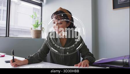 Writing woman at desk by window, using black pen, accessories and plant under shopping cart overlay Stock Photo