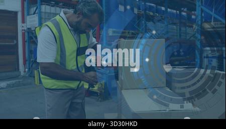 Scanning worker wearing yellow vest using handheld barcode scanner on box in warehouse, copy space Stock Photo