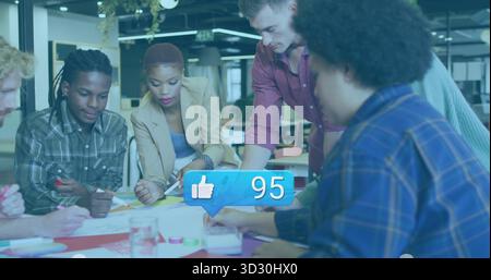 Collaborating coworkers writing around table in open office, with papers, sticky notes and markers Stock Photo