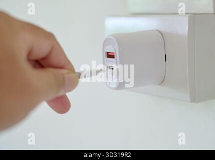 Minimal Close-Up of Person Plugging Charger Cable In Stock Photo