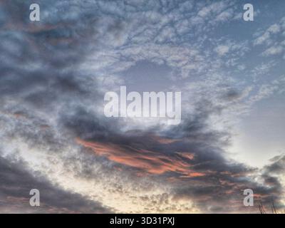 High Altocumulus Clouds at Sunset/Sunrise. Pastel Sky Cloudscape. Soft Blue and Pink morning Sky Stock Photo
