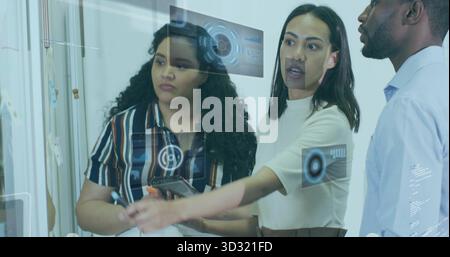 Analyzing data team wearing business attire using glass panel in office, holding tablet and stylus Stock Photo