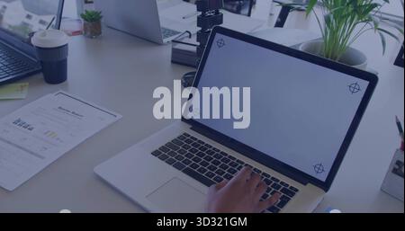 Typing worker hand pressing keys on primary laptop at white desk, with coffee cup, report, plants Stock Photo