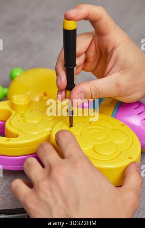 Father repairing toy using screwdriver at home Stock Photo
