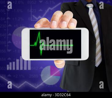 broker dealer showing the market stock in his phone with graphs in the background Stock Photo