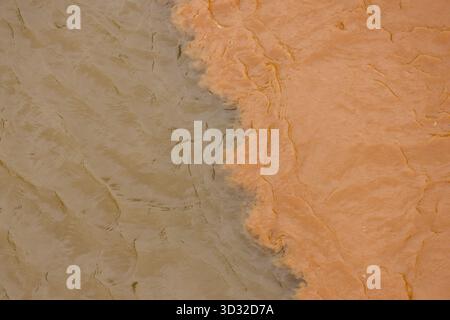 Abstract background texture of rough orange and green plaster wall. two tone surface creates calm and earthy decorative pattern with distinct separati Stock Photo