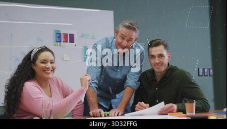 Three designers wearing shirts discussing smartphone layouts in conference room, with glass board Stock Photo