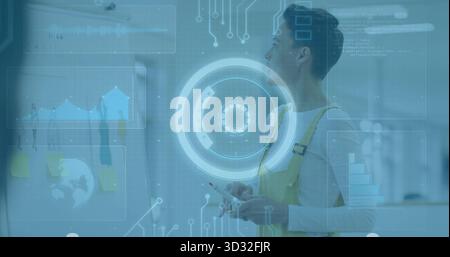 Engineer wearing yellow overalls examining HUD in modern office with glass board notes, copy space Stock Photo