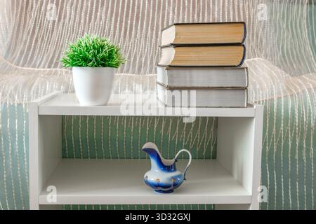 books, flower, vase on white bookcase Stock Photo