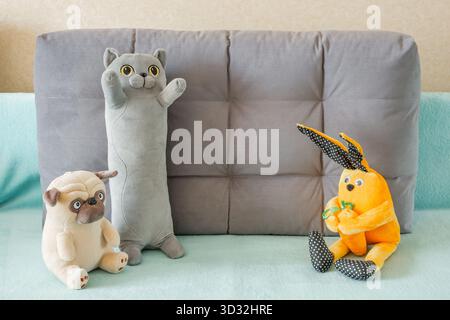 soft plush toys cat dog and rabbit on sofa Stock Photo