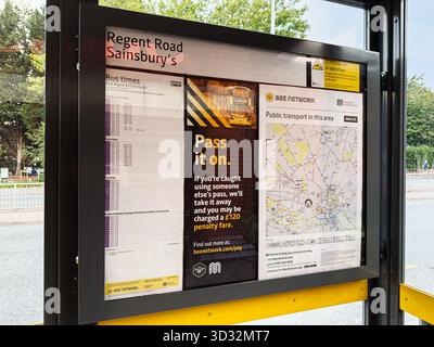 Salford, UK - September 29, 2025: Public transport display at Salford bus stop shows timetables, maps, and local advertisements Stock Photo