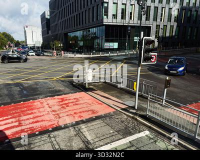Manchester, UK - September 29, 2025: Urban street scene with crosswalks, traffic lights, and The Manchester College in Manchester. Stock Photo
