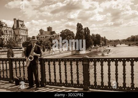 PARIS - Aug 14: Unidentified young saxophone player on the bridge as seen on August 14, 2013 in Paris, France. Dozens buskers perform on the streets a Stock Photo