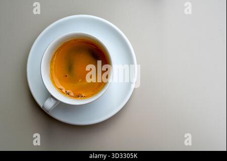Ceramic white cup with black espresso coffee on a table, space for text Stock Photo