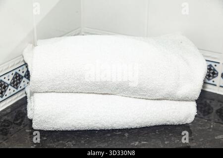 Clean white towels lie folded in the bathroom Stock Photo