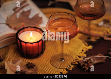 Cozy Autumn Scene with Wine Glasses and Candle Stock Photo