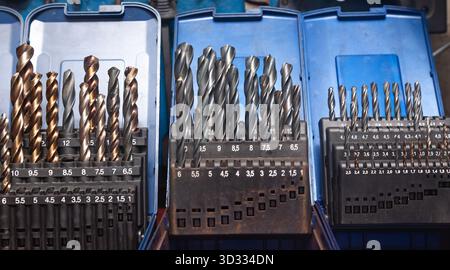 Sets of drills on a table in a workshop. Stock Photo