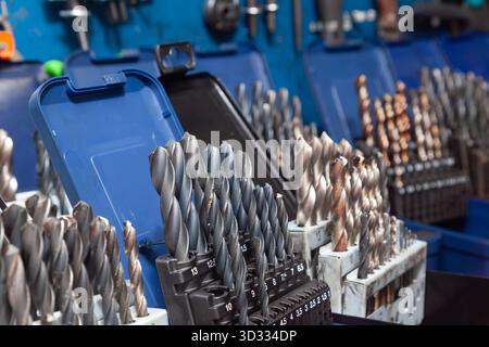 Sets of drills on a table in a workshop. Stock Photo