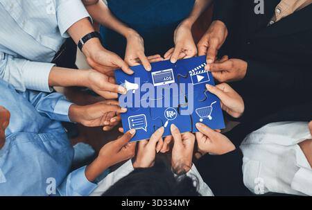 A diverse group of individuals collaborating to complete a puzzle, symbolizing the importance of teamwork and innovative strategies in marketing and a Stock Photo